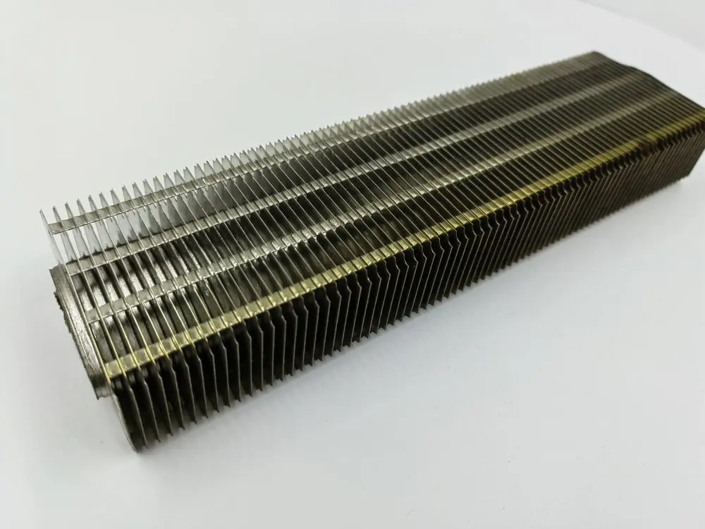 Close-up view of elliptical fin tubes in a manufacturing facility showing spiral-wound fins on elliptical base tubes